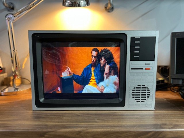 Retro CRT TV with speaker grille playing a music video to hire