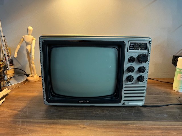 Grey 1980s portable television with rotary controls to hire