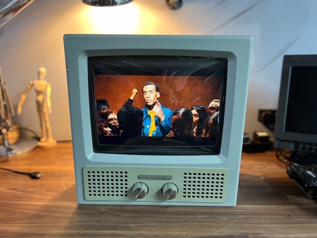 Pale grey retro television playing concert video to hire